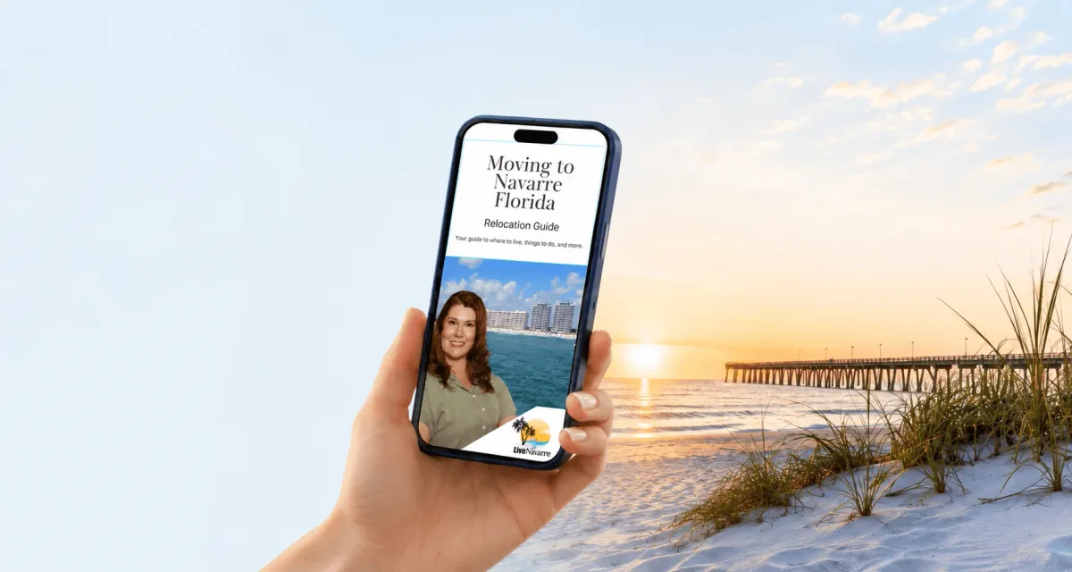 A hand holding a phone that shows the Moving to Navarre Florida relocation guide, with a sunset beach and pier behind it