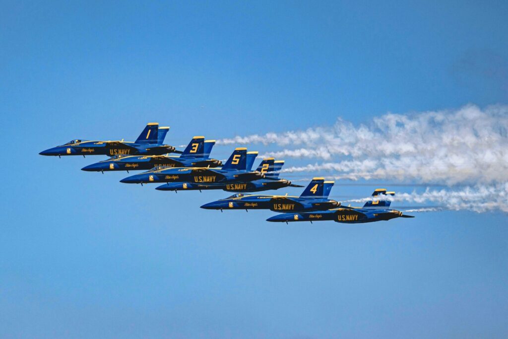 a group of blue jets flying in the sky